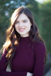 Girl in purple sweater with arms crossed